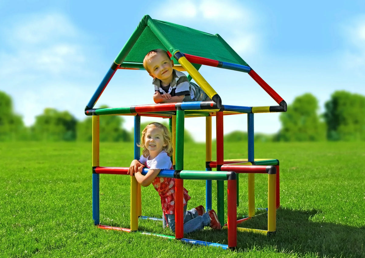 Two children playing in a covered QUADRO Junior playhouse outdoors