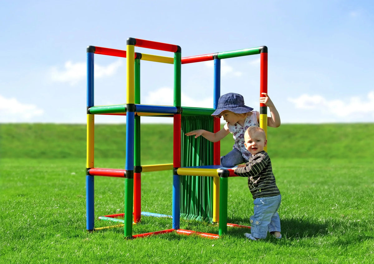 Two children playing in a QUADRO Starter cube tower with green curtain