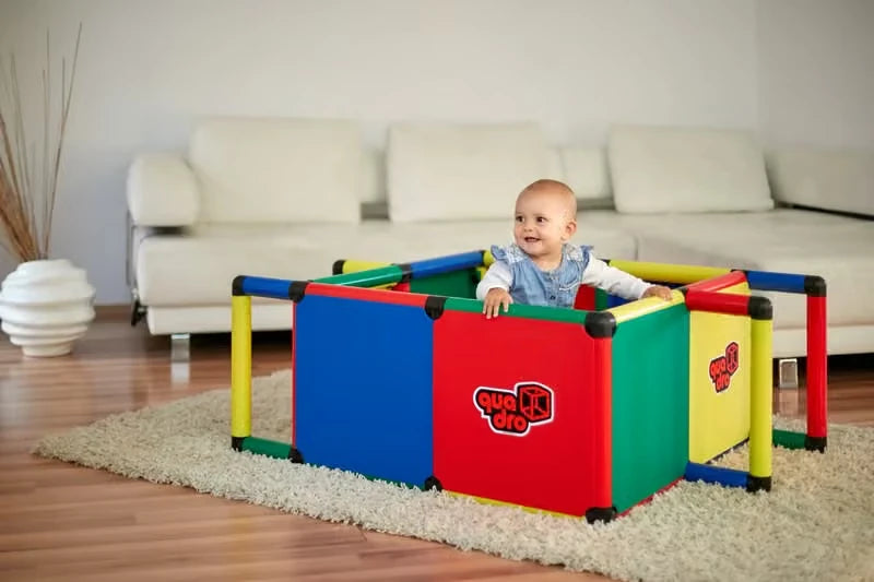Baby standing inside a large QUADRO playpen made with coloured XXL panels